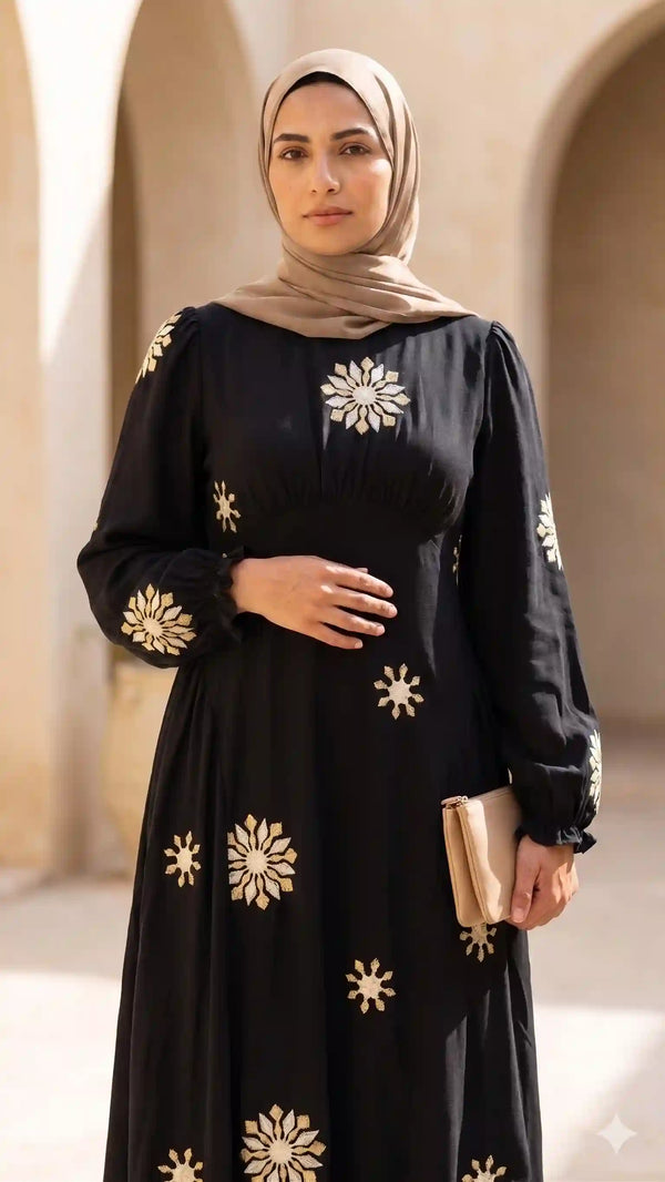 فستان أسود بتطريز ذهبي مع حجاب بيج.